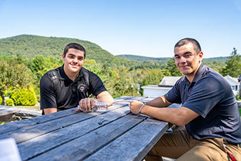 Two students sit outside together. Links to What to Give
