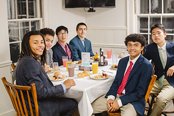 Students sitting at a table, enjoying a group breakfast together. Links to Gifts That Pay You Income
